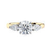 Lab grown diamond trilogy style engagement ring with pear sides gold front view.