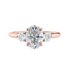Laboratory grown diamond oval three stone diamond engagement ring with round side stones 18ct rose gold front view.