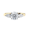 Round 3 stone natural diamond engagement ring with pear shoulders in gold front view.