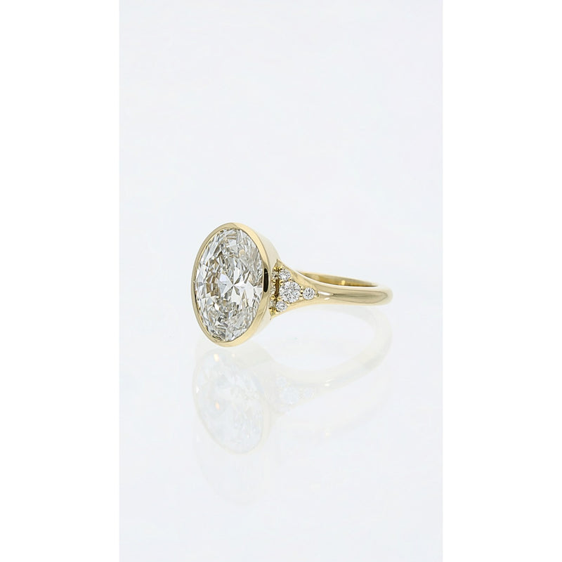 bezel set oval diamond engagement ring with shoulder set diamond detail