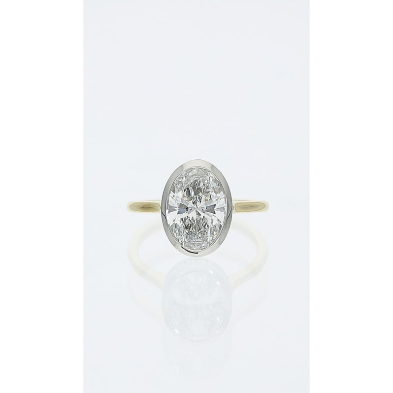 oval bezel set diamond ring in yellow gold with hidden halo detail