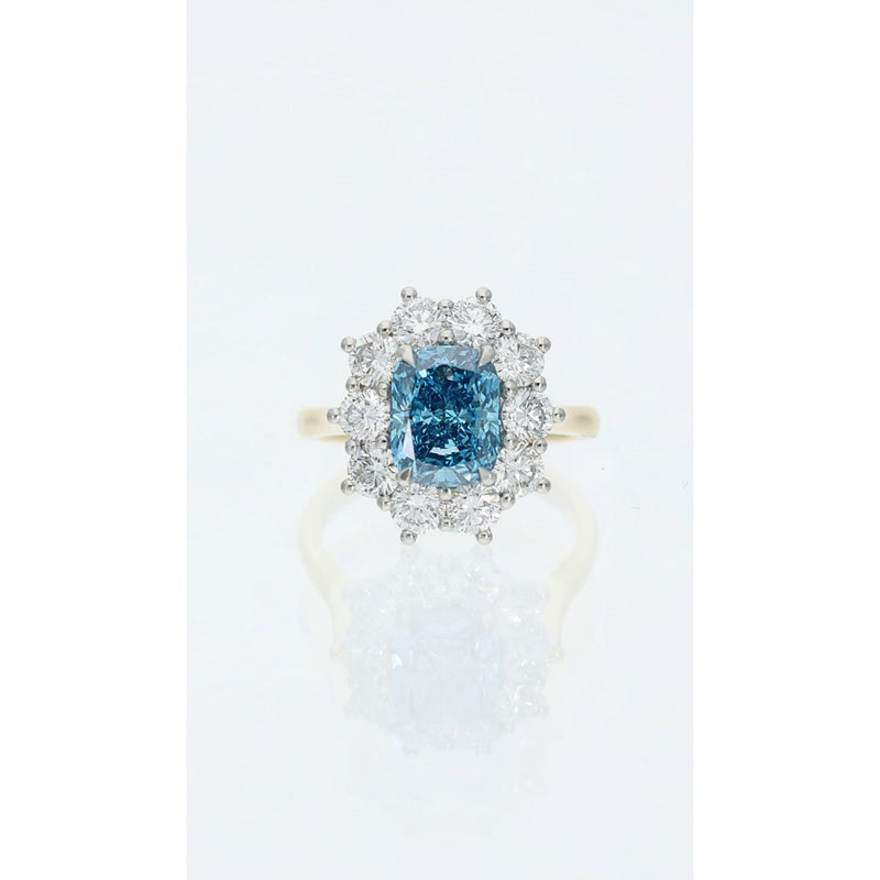 Fancy vivid blue cushion cut diamond cluster ring in gold and platinum