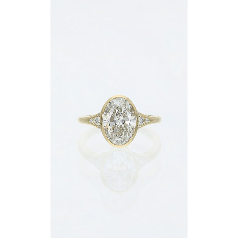 oval bezel set diamond ring in yellow gold with diamond detail band