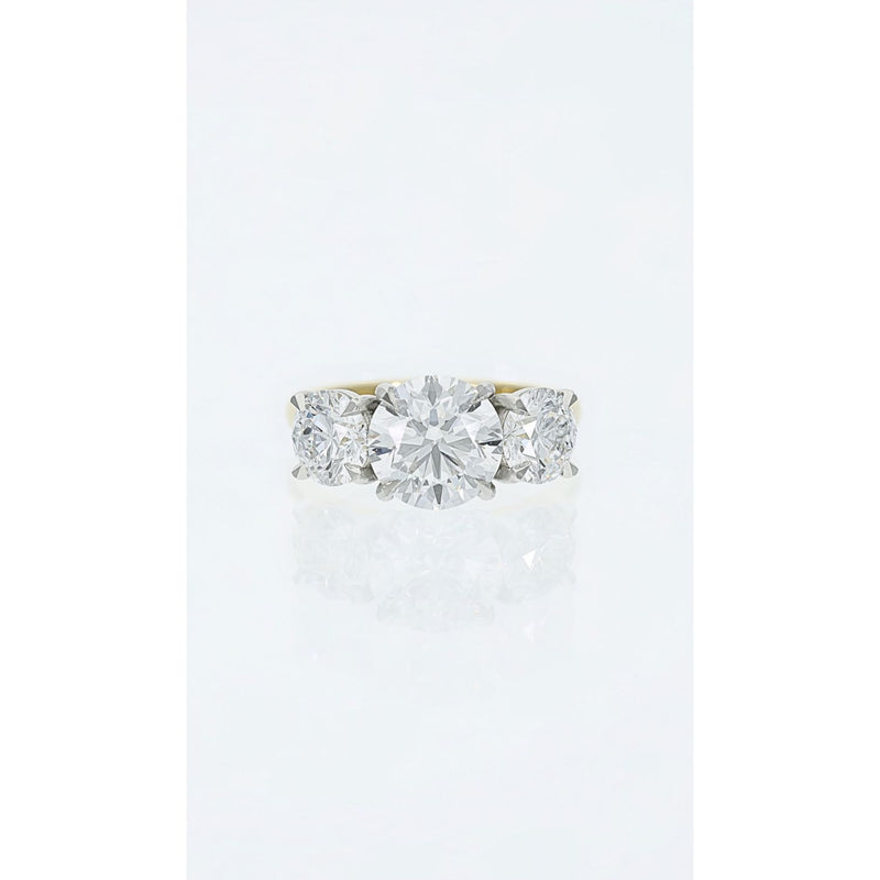 three stone diamond ring with round centre and side stones in platinum and gold