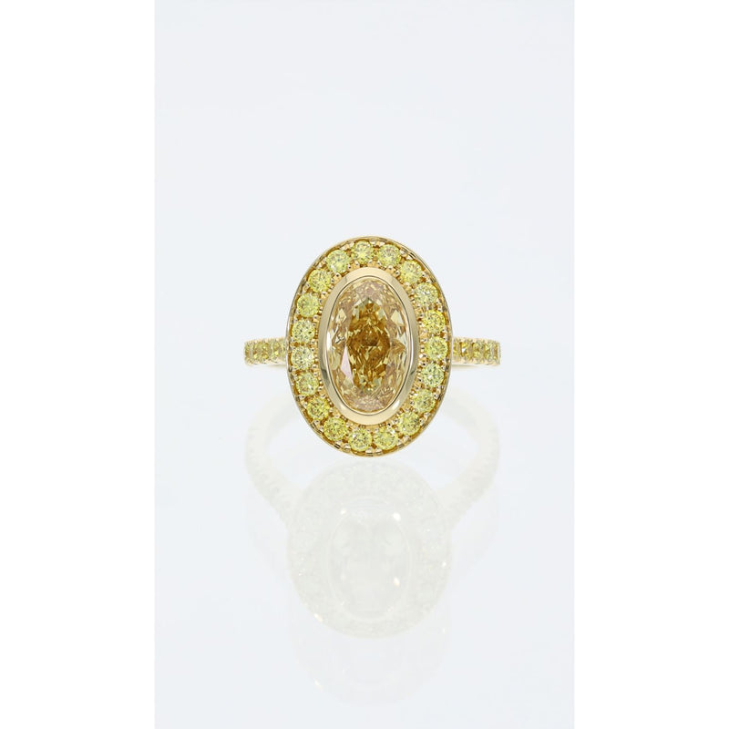 Fancy vivid yellow oval cut diamond halo ring in 18ct yellow gold