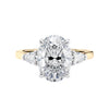 3 stone oval and pear diamond engagement ring gold front view.
