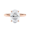 Oval solitaire diamond engagement ring with a hidden halo in rose gold front view.