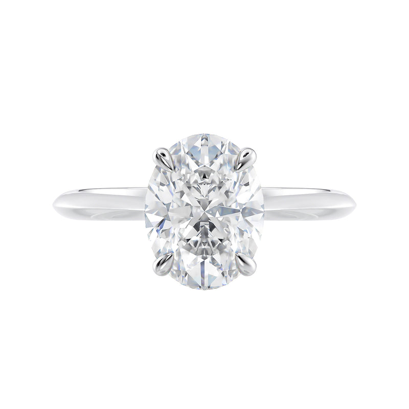 Oval solitaire diamond engagement ring with hidden halo and knife edge shank white gold front view.