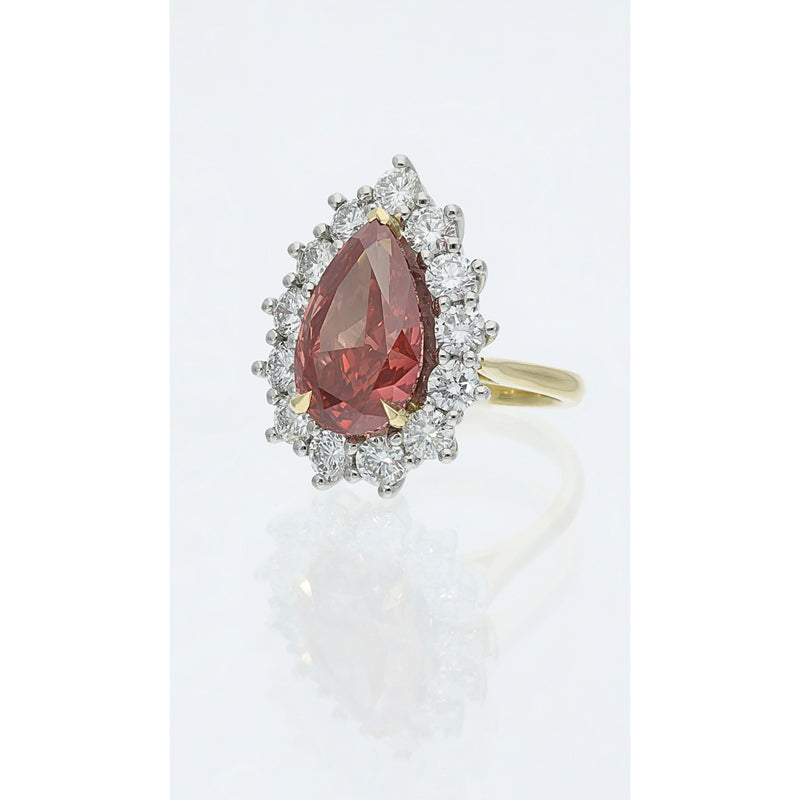 Fancy Vivid reddish pink pear cut diamond cluster ring with 6.08ct centre stone and diamond halo in platinum and 18ct gold