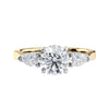 Round and pear three stone natural diamond engagement ring in 18ct yellow gold front view.